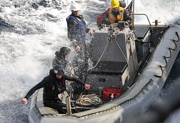 Sailors assigned the guided-missile destroyer USS John S. McCain (DDG 56) steer their rigid-hull inflatable boat alongside the ship after investigating several Japanese boats that appeared to be adrift.