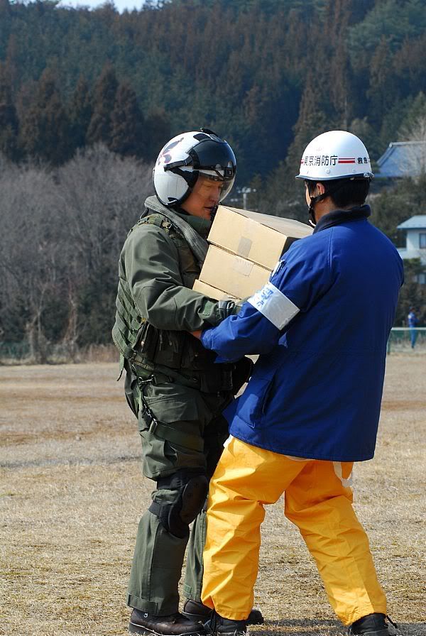 Lt. Cmdr. Albin Quinko hands over supplies to a Japanese aid worker during earthquake and tsunami relief efforts near Sendai, Japan.