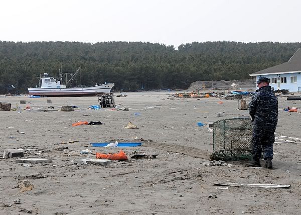 A Sailor assigned to Naval Air Facility Misawa (NAFM) hauls debris during a cleanup effort at the Misawa Fishing Port.