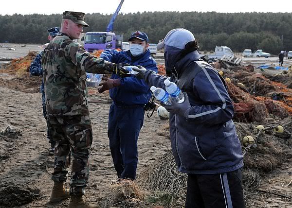 Chief Construction Mechanic Michael Robb, from Port Hueneme, Calif., assigned to Naval Air Facility Misawa, hands out water to Sailors, Misawa city workers and civilian volunteers during a cleanup effort.